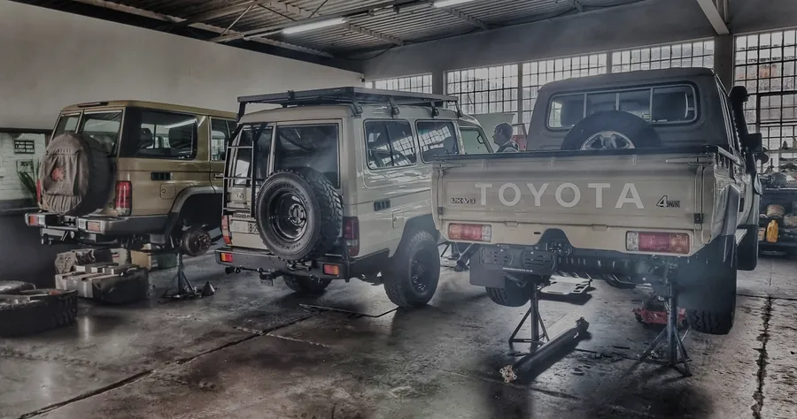 Land Cruiser 70 Series station wagons and a double cab on stands